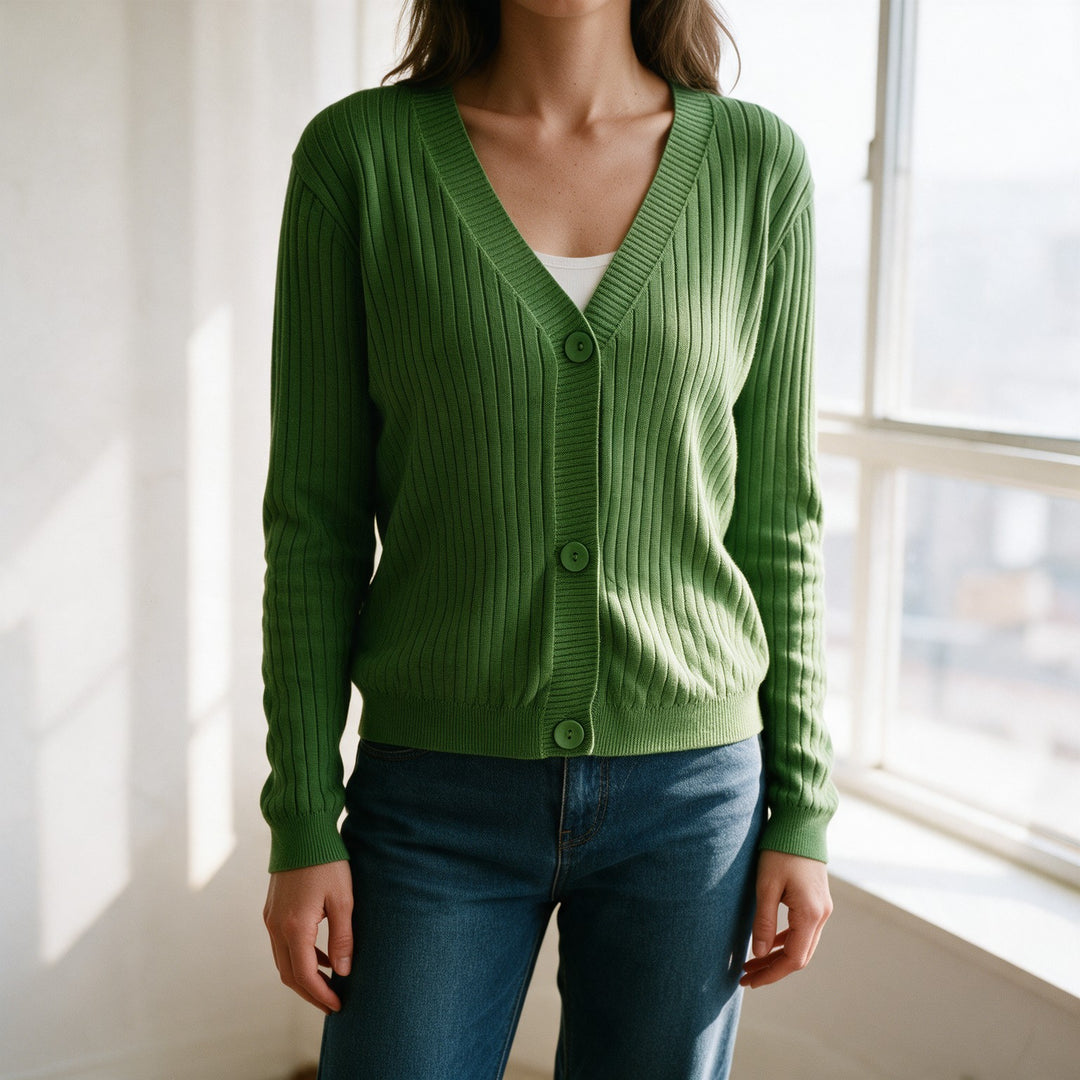 Woman wearing a green ribbed cotton cardigan over a white top